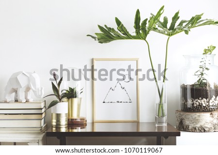 The stylish interior with mock up poster frame, plants, books, leafs and elephant sculpture. The retro concept of space.
