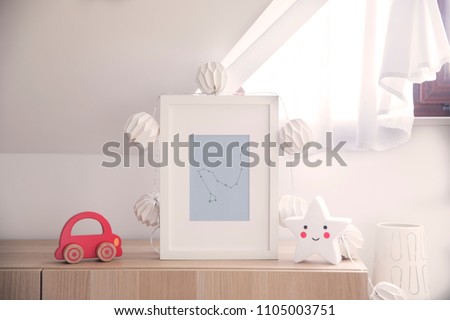 Stylish nursery interior with mock up photo frame , cotton lamps, star and red car toy. White and sunny background wall.