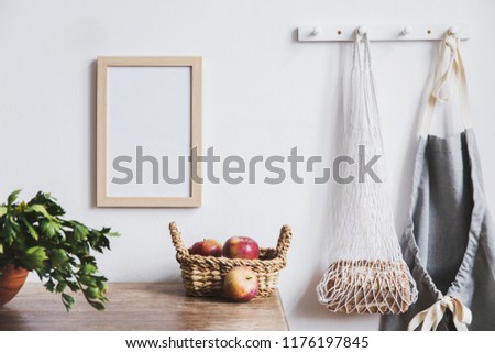 Vintage kitchen interior with mock up photo frame, straw basket, and kitchen accessories. Minimalistic concept of kitchen space.