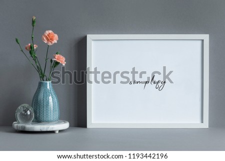 Stylish and minimalistic composition of mock up photo frame with flowers in vase. Modern concept of mockup frame.