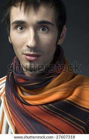 Portrait of a young business man with colorful scarf on dark background