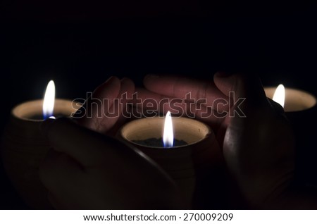 Hands holding a burning candle
