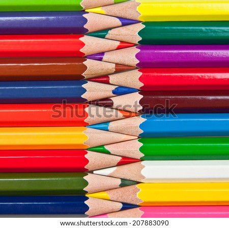 sharpened colored pencils lined up in a row against each other
