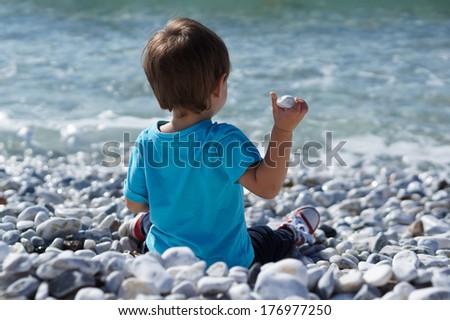 boy throwing stones in the sea