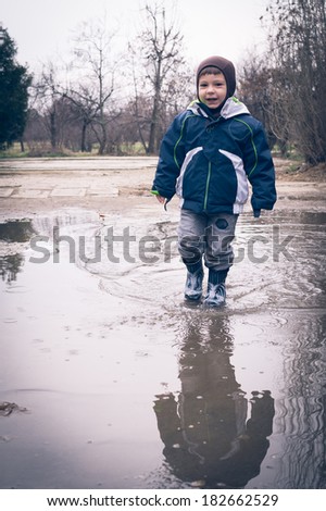 child walking in a dirty pool of water