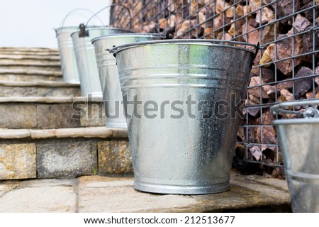 Wet Metal Buckets on stone stairs and wall