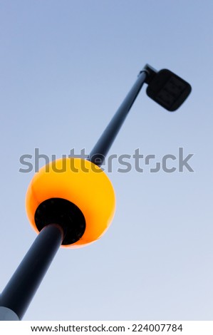 photo of street light pole with lighted globe and blue sky