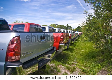 A row of Toyota trucks in a dealer\'s back lot.
