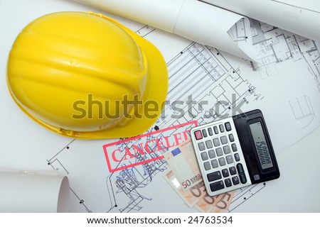 hardhat, euro money, calculator on blueprints, canceled project