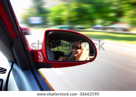 pretty woman in a car in mirror in motion