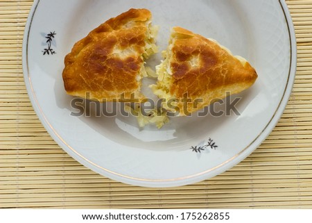 Fried pies with cabbage on a bamboo napkin