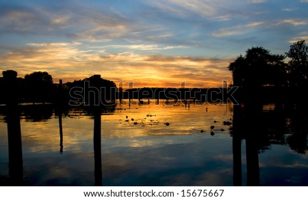 Beautiful sunset reflecting off of a body of water near a boat dock.