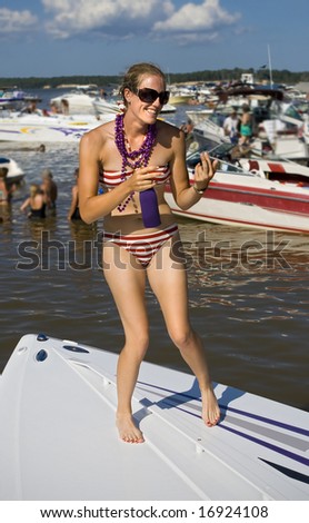 Young attractive woman dancing on front of boat.