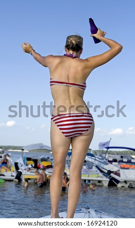 Young attractive woman dancing on front of boat.