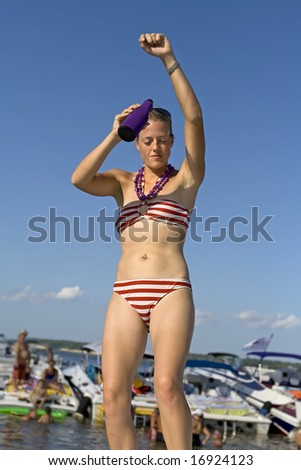 Young attractive woman dancing in a red and white striped bikini.