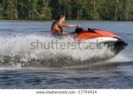 Man riding a wave runner in a river enjoying a nice summer day.