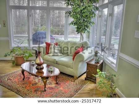 Interior of a corner room with tall windows and a view outside.