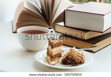 Cup of tea, cake and some books to read lying on the table
