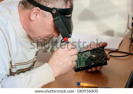 Man repairs a motherboard