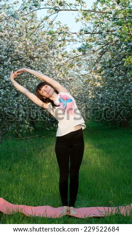 Young woman doing yoga on a natural background. Spring garden