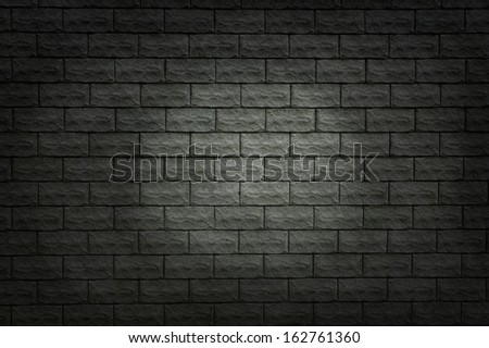 Grunge wall texture of the gray tiles. Spot of light on the dark gray wall.