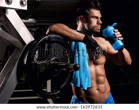the man in the gym drinking from the shaker
