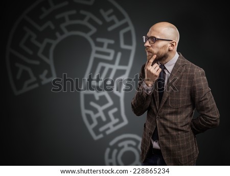 Adult bald man with a beard, thinking over the matter.