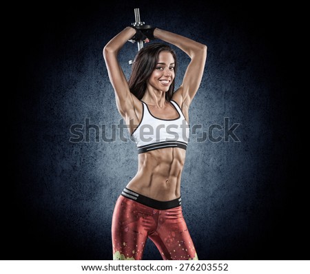 young beautiful girl with a sports figure doing exercises with dumbbells