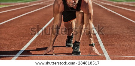 Athletic man starting evening jogging in sun rays