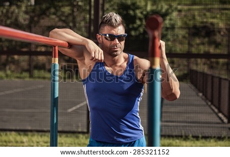 Handsome healthy happy strong athlete male man exercising at the city park