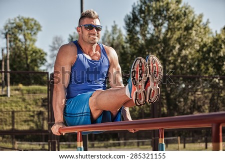 Handsome healthy happy strong athlete male man exercising at the city park