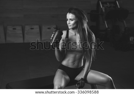 Fitness girl with shaker relaxing in the gym