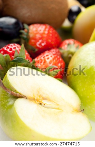 Assorted fresh fruits background including strawberry, apple, kiwi and black and green grape