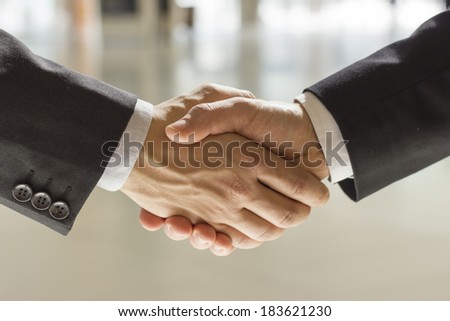two businessman shaking hands  bright background