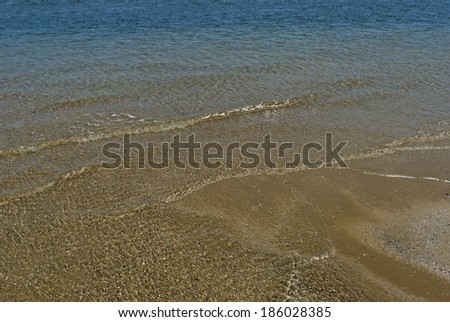small waves rolling into shore at Australian coastline closeup