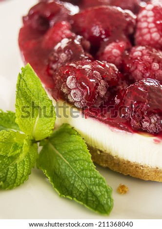 Fresh raspberry cheesecake served with mint leaves.
