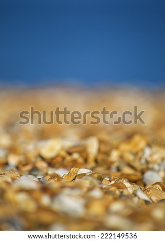 Pebbles with shallow depth of field and the sea in the background