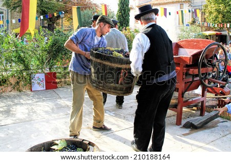 CHUSCLAN, FRANCE - October13, 2013: Traditional Wine Pressing using a manual grape crushing machine during the festival \