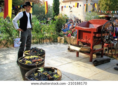 CHUSCLAN, FRANCE - October13, 2013: Traditional Wine Pressing using a manual grape crushing machine during the festival \