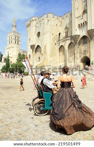 AVIGNON, FRANCE - JULY 19, 2014: Actors in historical costumes advertising their performance in front of the Papal Palace during famous theater festival July 4- 27, 2014 in Avignon, south of France.