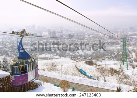 ALMATY, KAZAKHSTAN - MARCH 10, 2014: funicular with tourists and view of the foggy city of Almaty, Kazakhstan