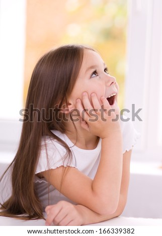 Little girl is holding her face while listening to somebody