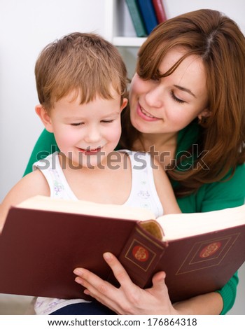 Mother is reading book with her son, indoor shoot