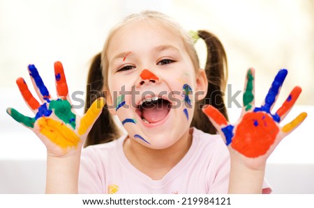 Portrait of a cute cheerful girl showing her painted hands
