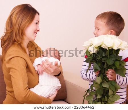 Mother holds cute baby, gift flowers for my mom