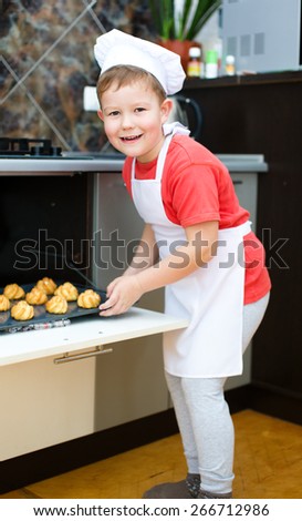 Cute boy making bread in the kitchen