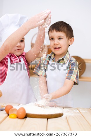 Cute children making bread in the kitchen