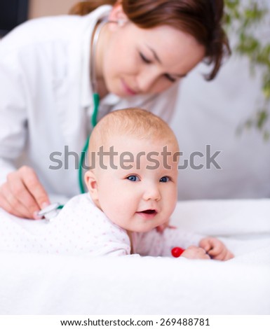 Doctor is examining cute little child
