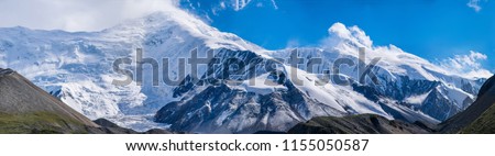 The panoramic mountain view with rocks and ice in Tian Shan mountains in Central Asia near Almaty covered by clouds. Best place for active life, climbing, hiking and trekking in Kazakhstan.