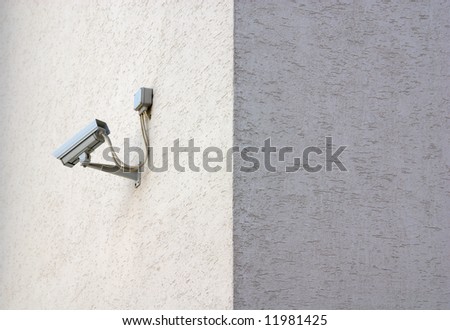 Security camera on sunlit building wall, no camera on shadow wall